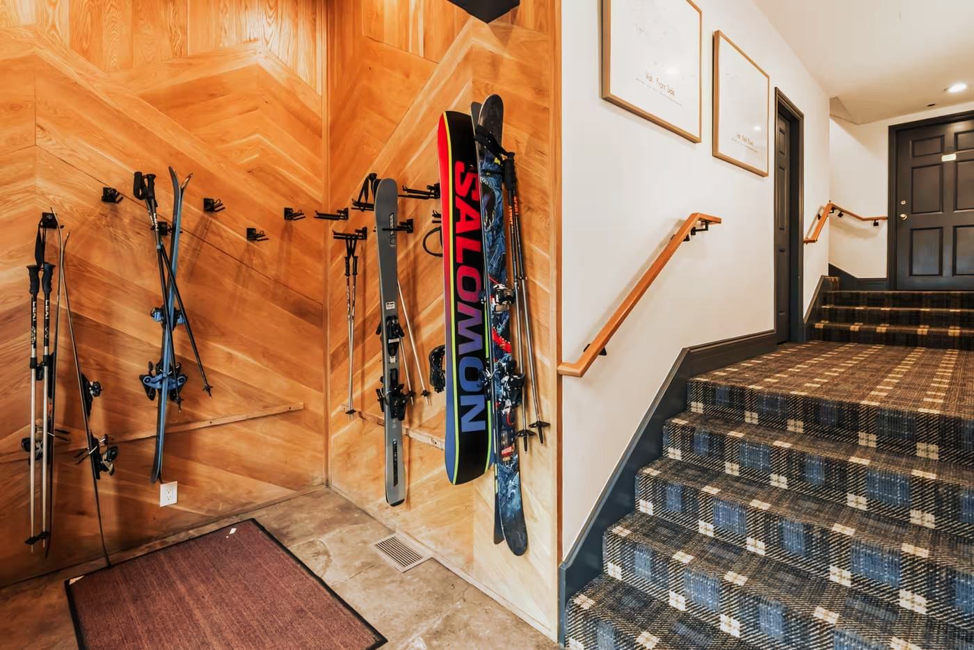 Racks of skis, boards and poles on a herringbone oak wall in the entry at 291 Bridge Street